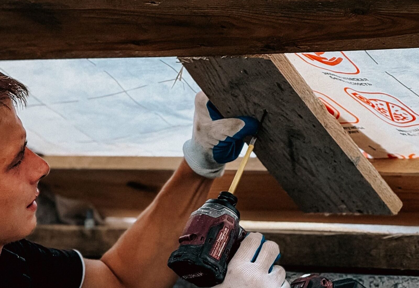 Contractor installing attic insulation and sheathing, a key ice-dam prevention step in Grand&nbsp;Rapids attics