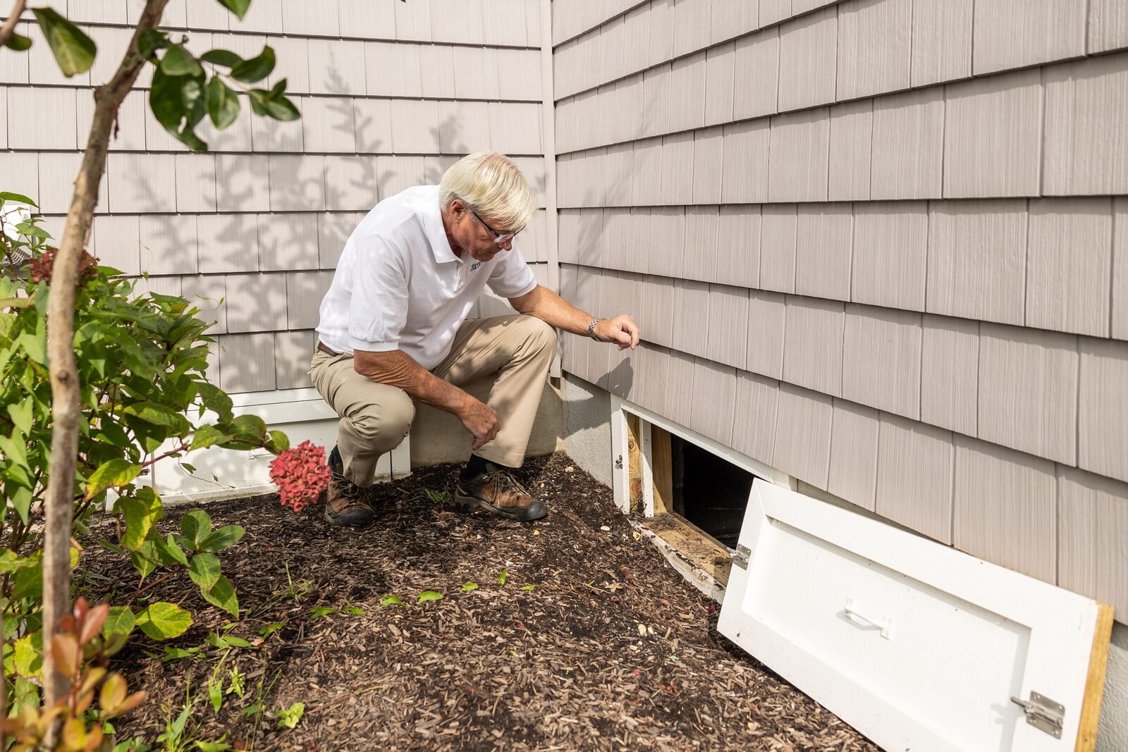 Professional evaluating a Grand Rapids home's exterior condition, representative of the licensed local expertise behind this FAQ hub