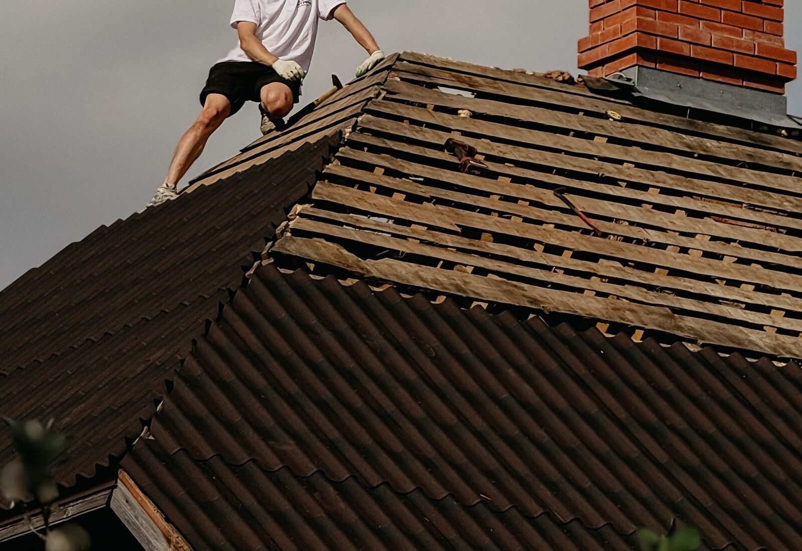 Professional roofer working on an asphalt shingle roof replacement, the kind of licensed, permitted work covered in this Grand Rapids licensing and verification guide