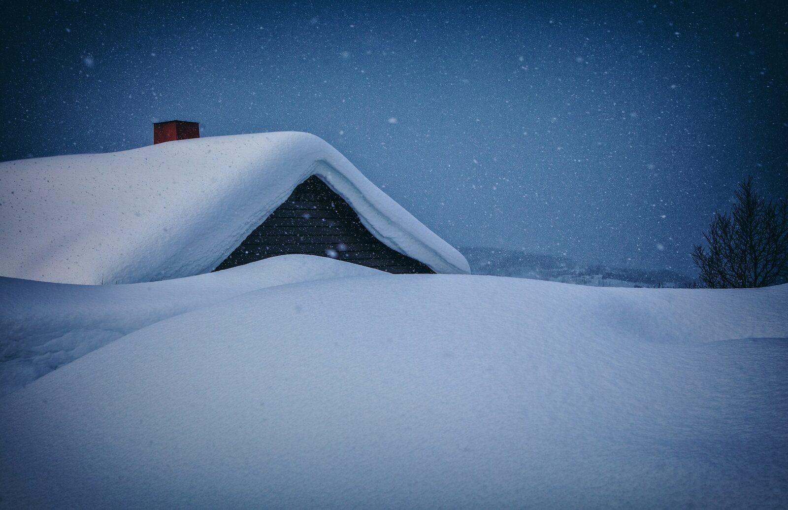 Heavy snow accumulation on a large home&rsquo;s roofline in Forest Hills, MI during a West Michigan winter storm