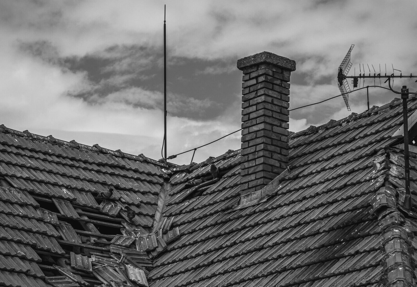 Close-up of broken roofing shingles after storm damage, a Kent County homeowner's first checklist item to photograph
