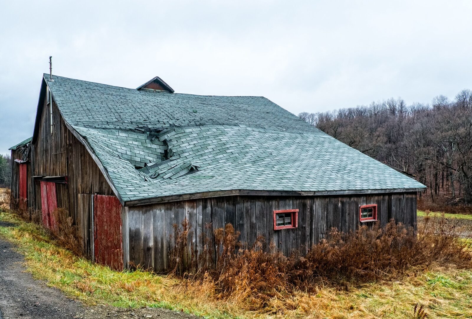 Wind-damaged, caved-in shingle roof section in need of emergency tarping in Grand&nbsp;Rapids, MI