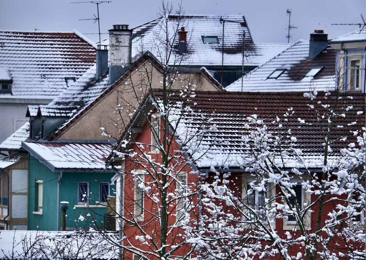 Close-up winter rooftop texture showing ice and snow buildup along a West Michigan eave line